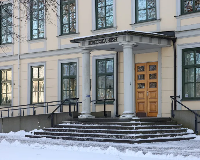 En stor byggnad med en gul dörr och trappsteg.