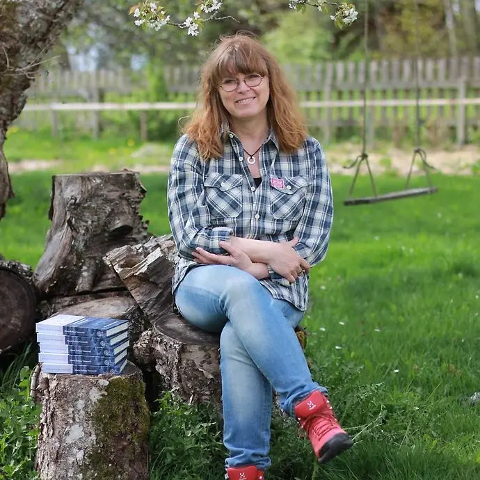 En kvinna som sitter i en stol utomhus