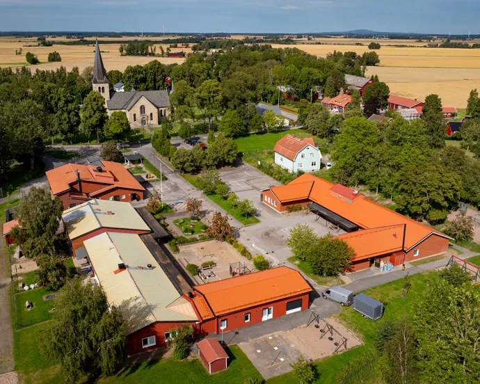 En flygbild över en skola omgiven av träd.