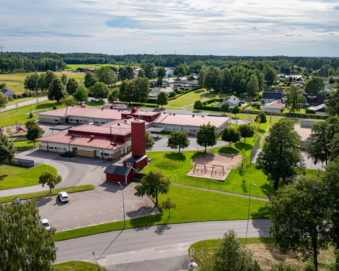En flygbild av en skolbyggnad omgiven av träd.