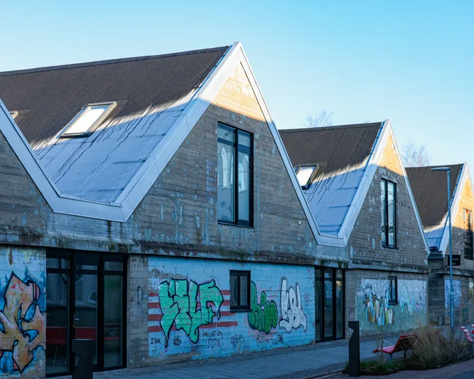 En rad hus med graffiti på sidan av dem.